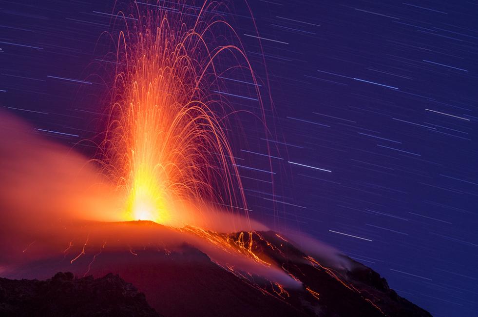 Fotografía de Joan de la Malla para Nthephoto. Espectacular erupción volcánica y trazos de estrellas.