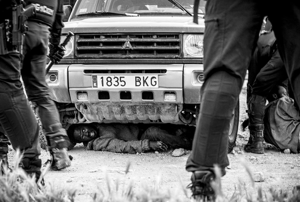Fotografía de Jesús Blasco de Avellaneda para Nthephoto. Un inmigrante subsahariano acaba de acceder a Melilla saltando el vallado fronterizo y se esconde bajo un vehículo para que las fuerzas españolas no lo expulsen a Marruecos