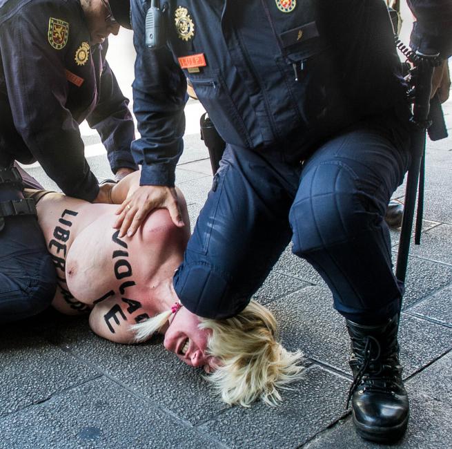 Fotografía de EDUARDO DIEGUEZ SAN BERNARDO para Nthephoto. Una activista de Femen es reducida por los antidisturbios tras realizar una acción contra el ministro del interior.