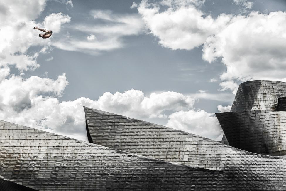 Fotografía de Pedro Luis Ajuriaguerra Saiz para Nthephoto. El saltador polaco Krzysztof Kolanus efectua uno de sus saltos magistrales junto al Museo Guggenheim de Bilbao durante las series mundiales Red Bull Cliff Diving